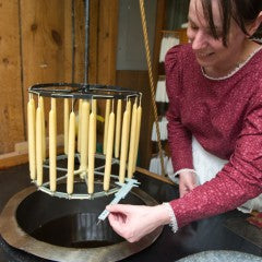 woman measuring dipped beeswax candles