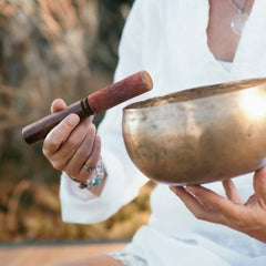 singing bowl being played by person in white top