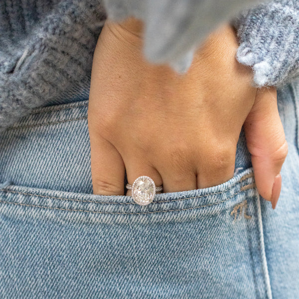 Oval diamond ring with hand in jean pocket