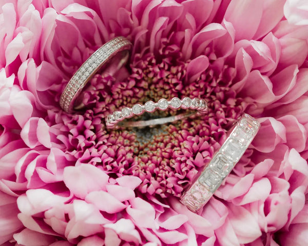 Diamond wedding bands on pink flowers
