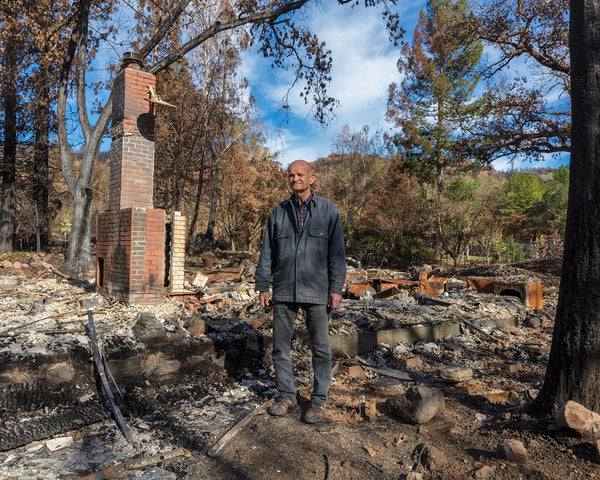 Man standing where wildfire destroyed the area