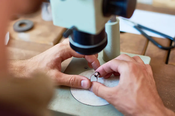 Jeweler looking with microscope at ring