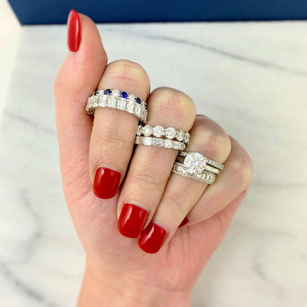 Blue gemstone and diamond rings on fingers