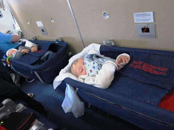 Babies sleeping in airplane bassinet