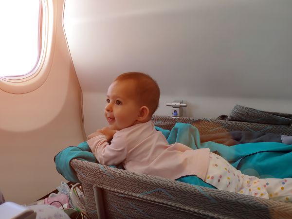 Happy baby in airplane bassinet