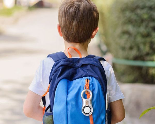 Little boy with tracking device on backpack