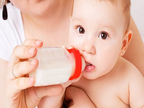 baby drinking milk from baby bottle