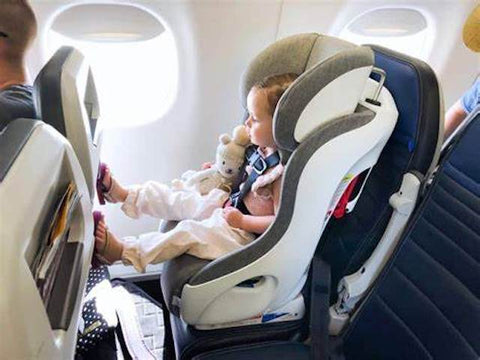 Toddler sitting in car seat on a plane