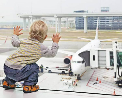 toddler looking out terminal window at plane