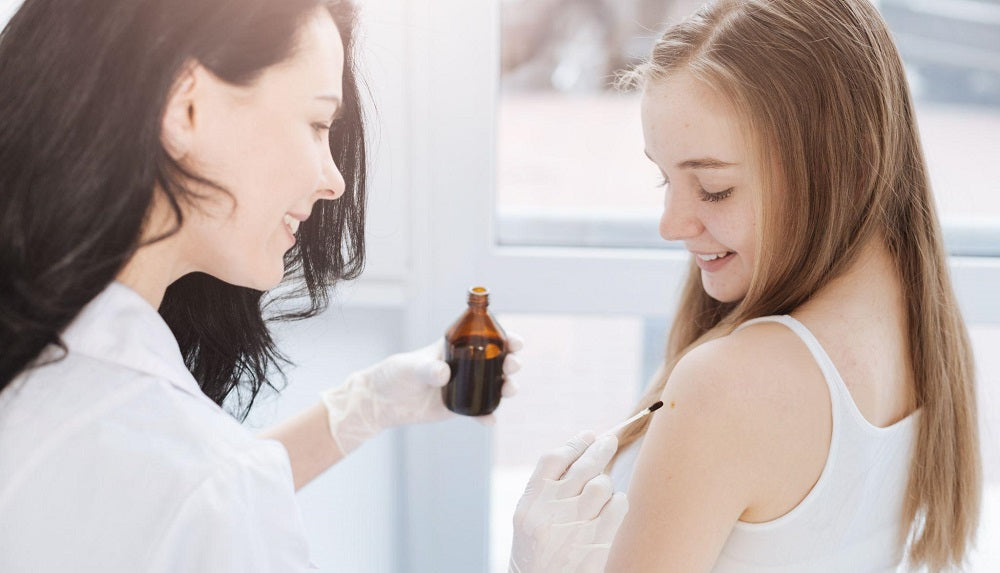 doctor applying liquid iodine to a teen girl