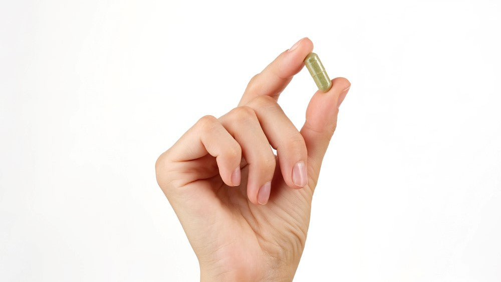 hand holding supplement capsule
