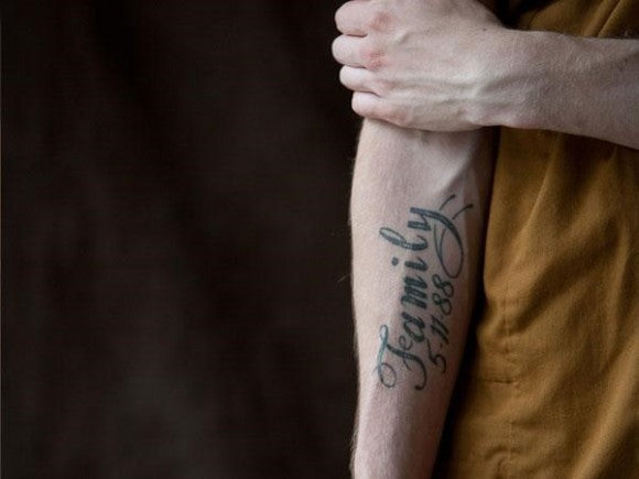 Homme avec le mot « Famille » tatoué sur son bras