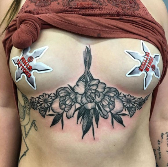 Blackwork Pfingstrosen-Bouquet sternum tattoo