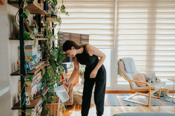 Young woman shows how to water houseplant