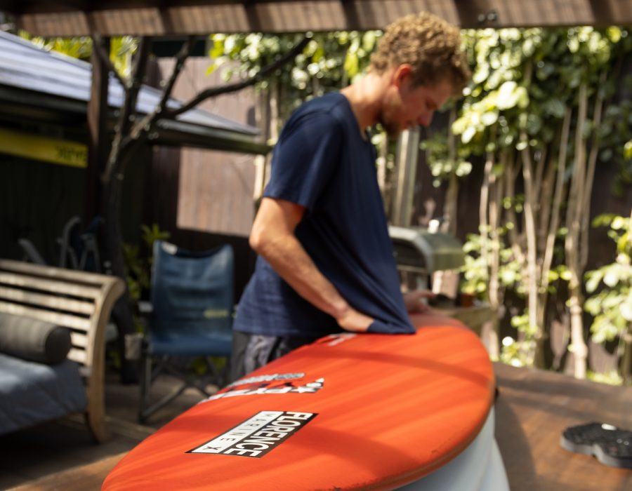 John John Florence cleaning and applying VEIA traction pad to pyzel surfboard