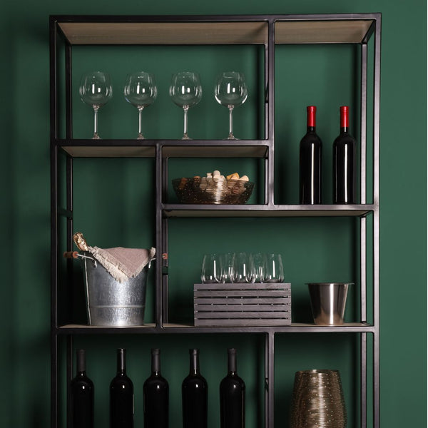 A metal wine rack in front of a green wall