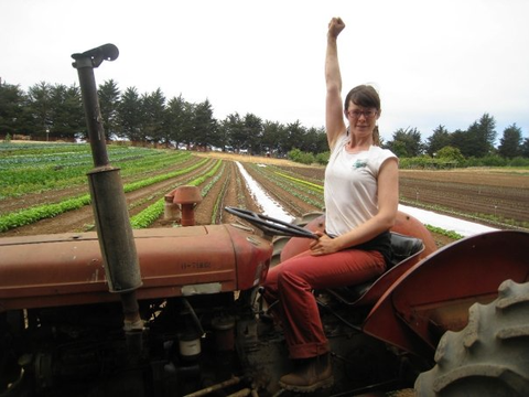 Molly Oliver riding a tractor at the UCSC Farm in Santa Cruz, California