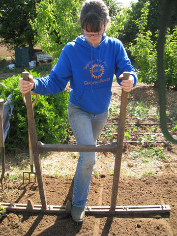 Molly Oliver Culver using a dibbler to prepare a bed for transplanting in the Down Garden at he UCSC Center for Agroecology Farm and Garden