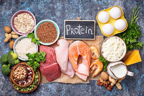 Assorted protein-rich foods and ingredients on blue backdrop