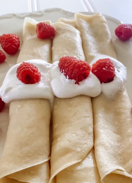 Three low-carb crepes with cream and raspberry on top