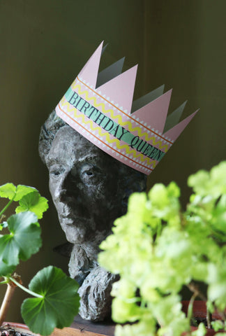 A beautiful bust of Quentin Crisp nestled amongst some geraniums and wearing our Birthday Queen paper crown card