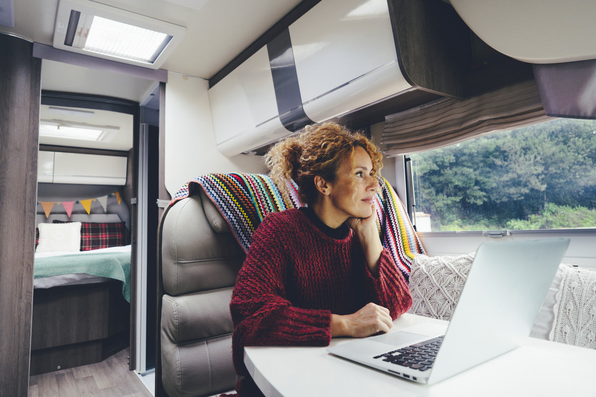 A woman works on laptop in camper RV 