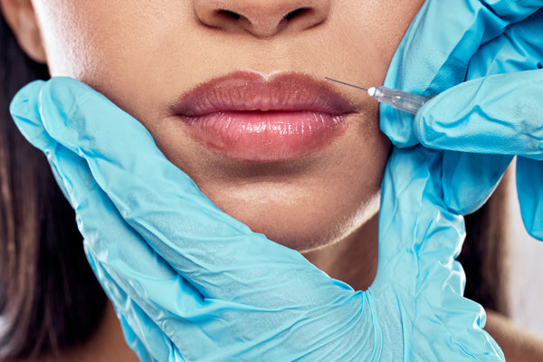 Woman's lips getting injected by injector nurse