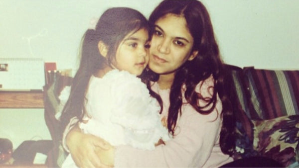 Daisy Grewal as a child receiving a hug from her mother