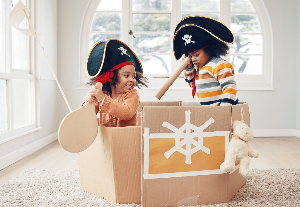 Children play with ship from cardboard