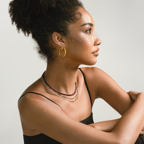 a photo of a model wears beautiful earrings and necklaces