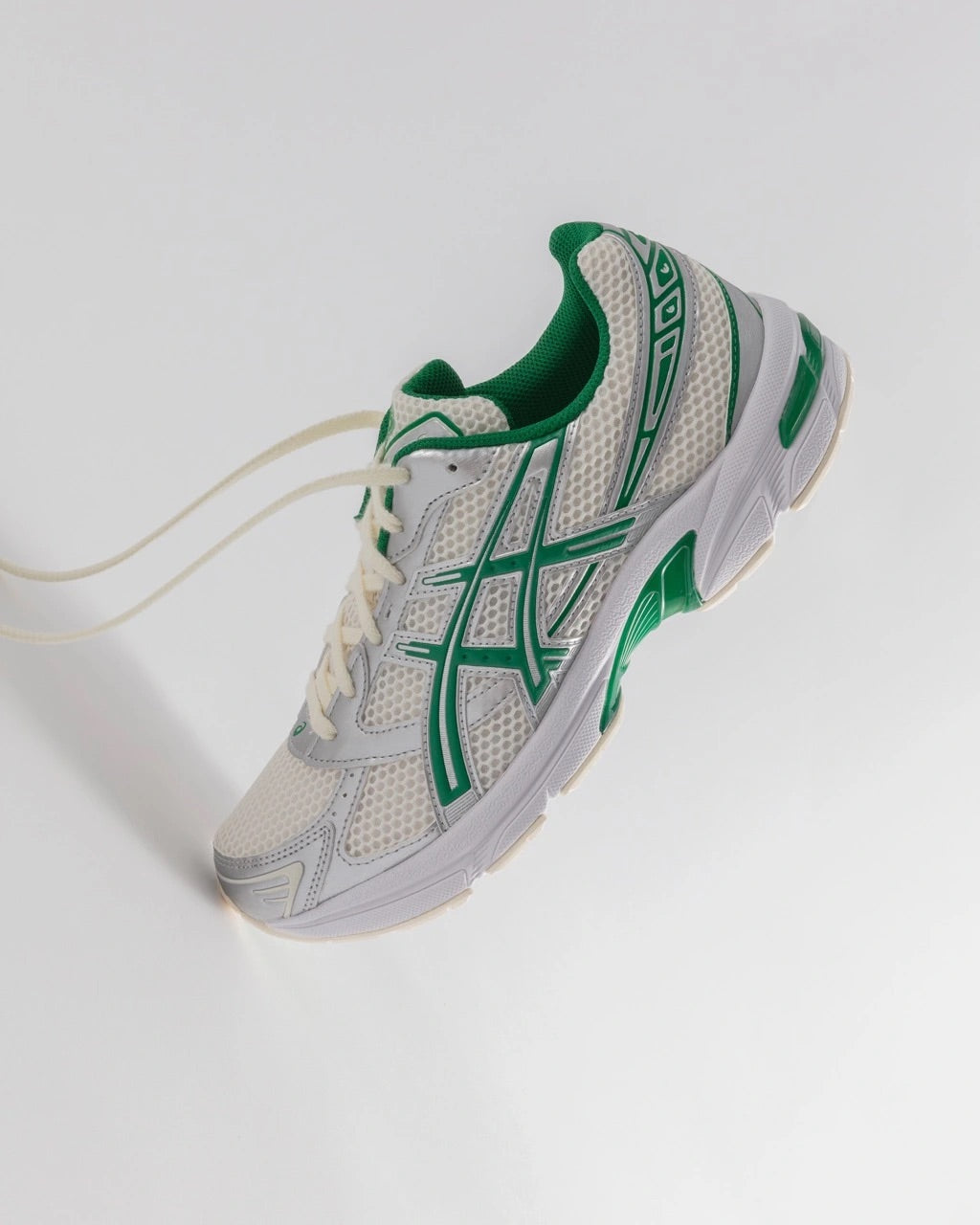 Image of the ASICS GEL-1130 Kale Pack sitting on its toe with the laces unlaced on a studio white background