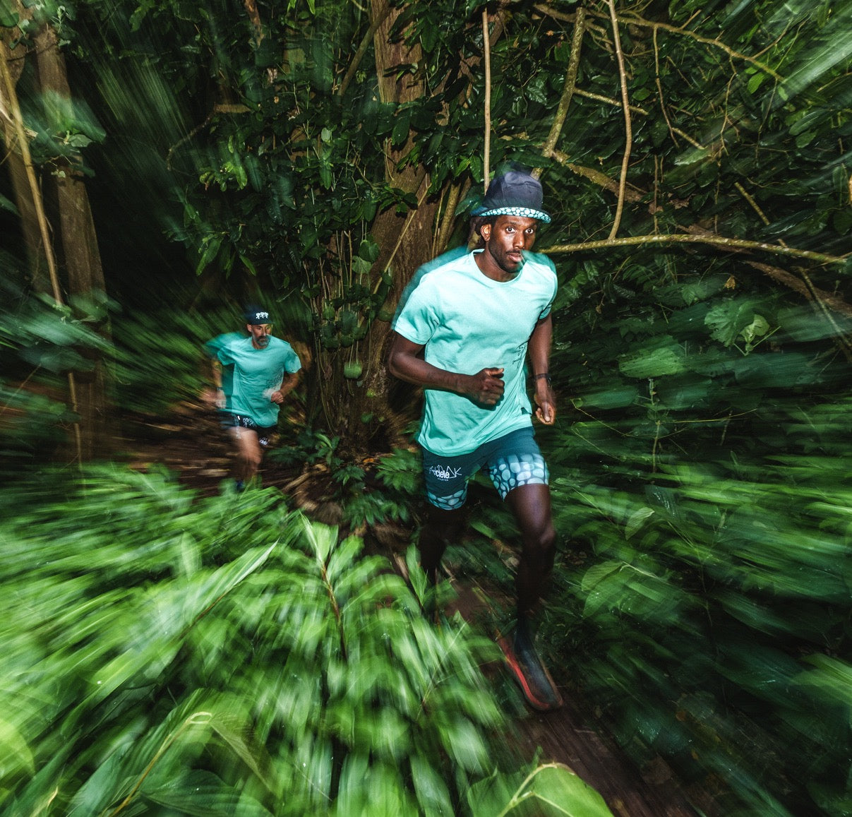 Man running in the jungle of Tahiti with the Roark x Cielo Mathis Knit Tee on