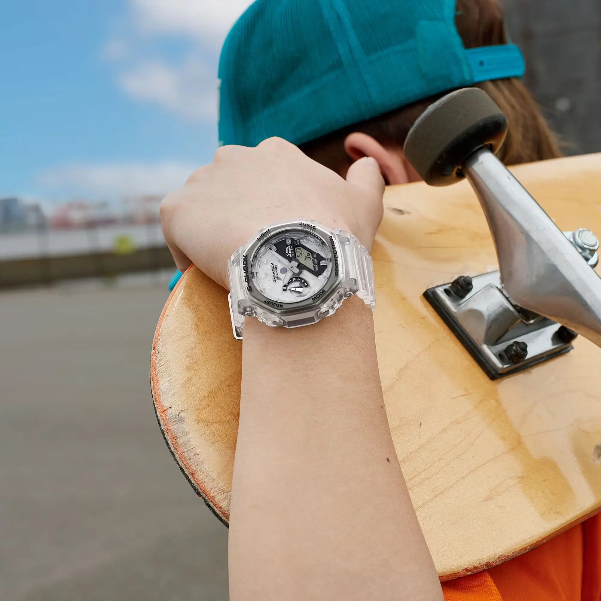 Skateboarder sporting the G-SHOCK GA2140RX-7A watch, featuring a transparent design, during an urban skateboarding session.