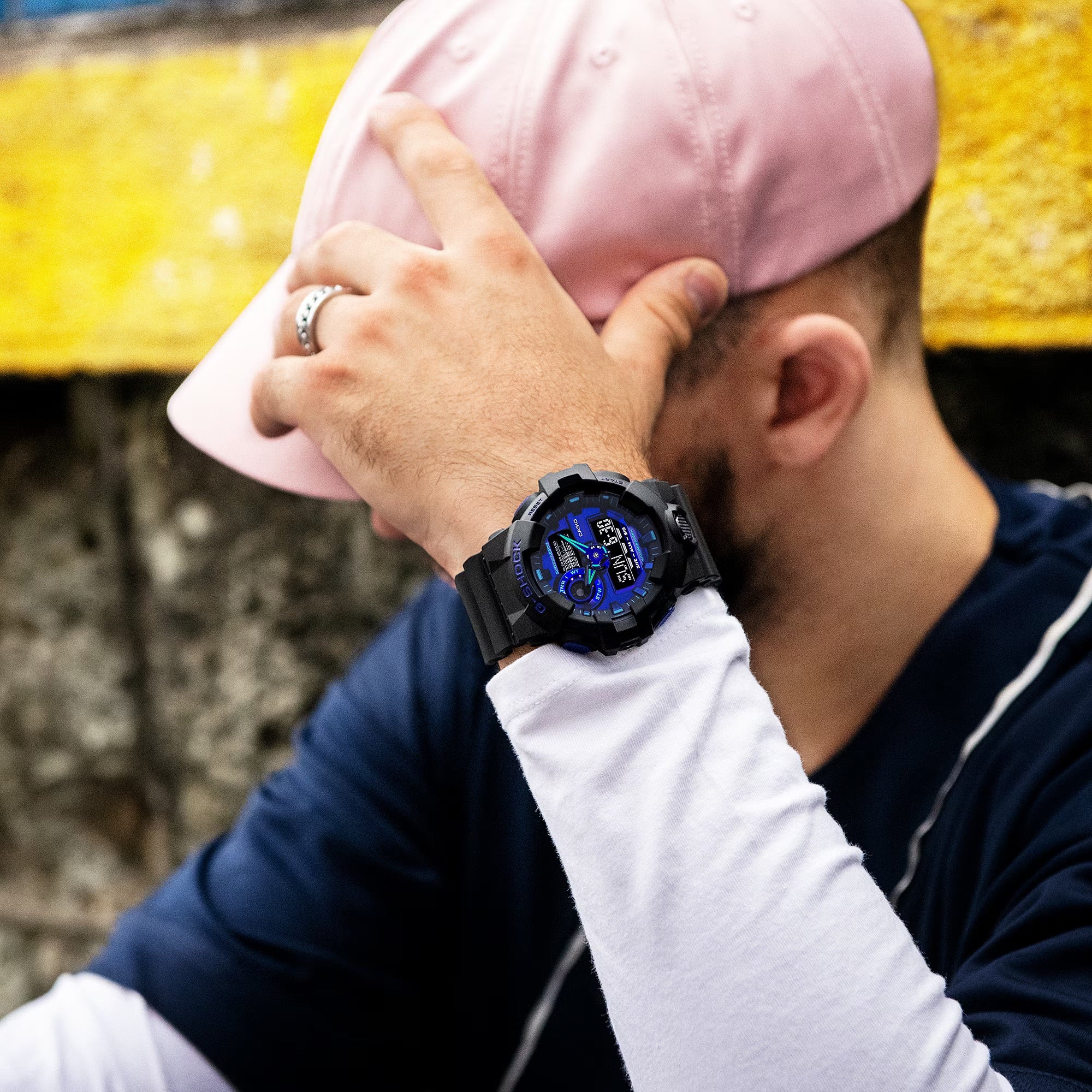Guy with a pink hat sporting the G-SHOCK GA-700VB-1A watch, featuring black and blue violet accents, exuding a trendy vibe.