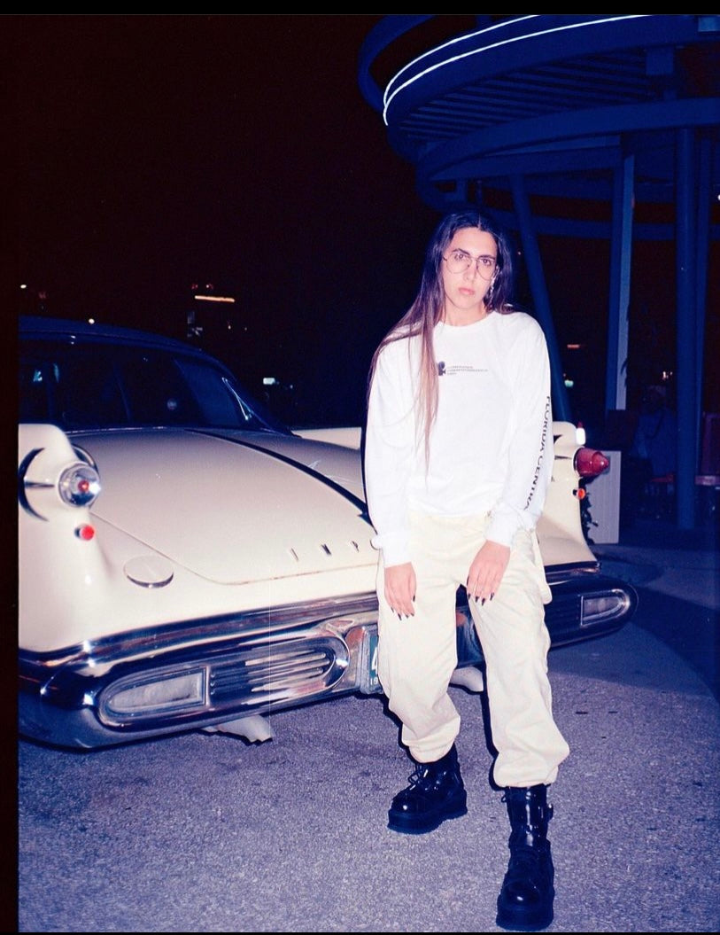 DJ Nedz the musician posed in front of a classic car