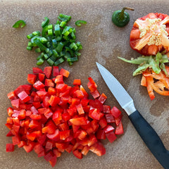 This image shows chopped peppers and food scraps on a cutting board