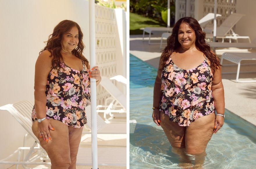 Woman with long brown hair poses by the pool wearing a black and floral ruffle swimsuit