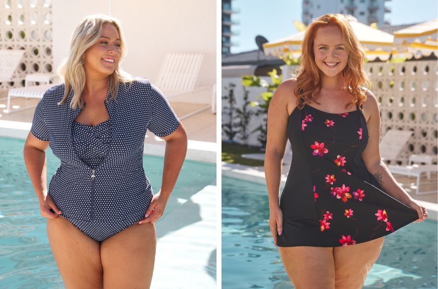 Woman with blonde hair wears navy and white polkadot short sleeve rash vest over matching strapless swimsuit. Woman with long red hair wears black and pink floral swim dress