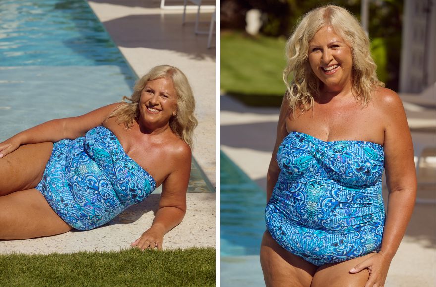 Woman with blonde hair poses by the pool in a strapless blue one piece swimsuit