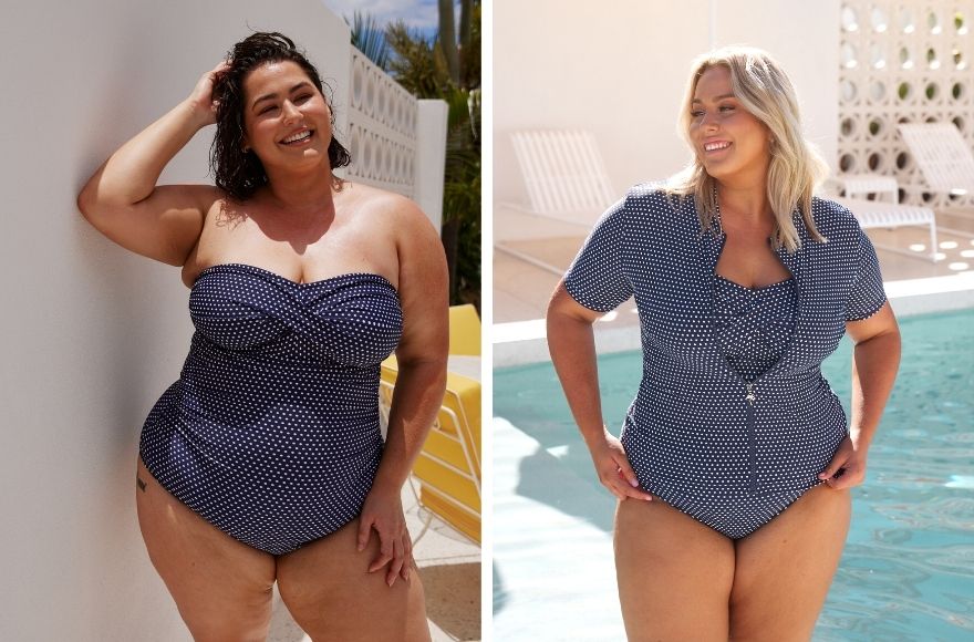 Woman with short brown hair wears Navy and White polkadots strapless one piece. Woman with blonde hair wears navy and white polkadot strapless one piece with a short sleeve rash vest over the top