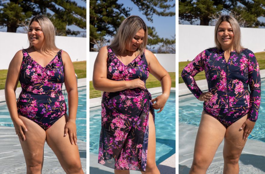 Woman poses in the pool wearing navy and pink floral swimwear