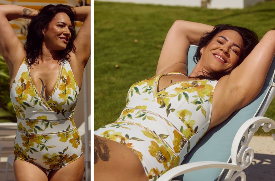 Woman with dark brown hair poses in a white v neck one piece with yellow floral print