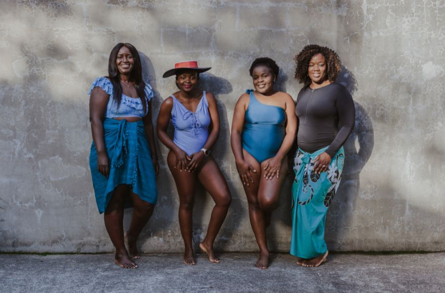 Four women wear different styles of swimwear with beach accessories and cover ups