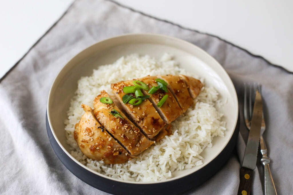 sous vide marinated chicken breast sliced and served on a bed of white rice