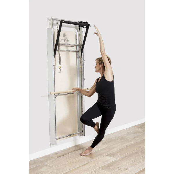 lady balancing on a space-saving Pilates wall board