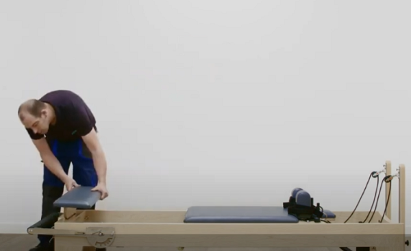 man assembling a new Elina pilates reformer machine