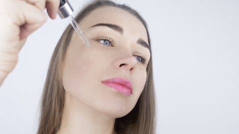 Woman applying retinol to her face