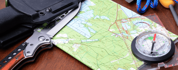 Military compass and topographical map for a bivouac