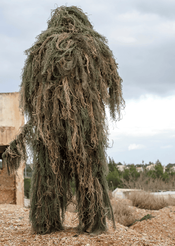 Soldier cleaning his ghillie follows