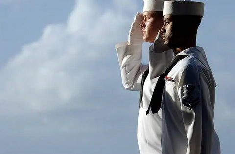 Soldaten, die den militärischen Gruß mit Käppis aus einem Käppiträger zeigen.